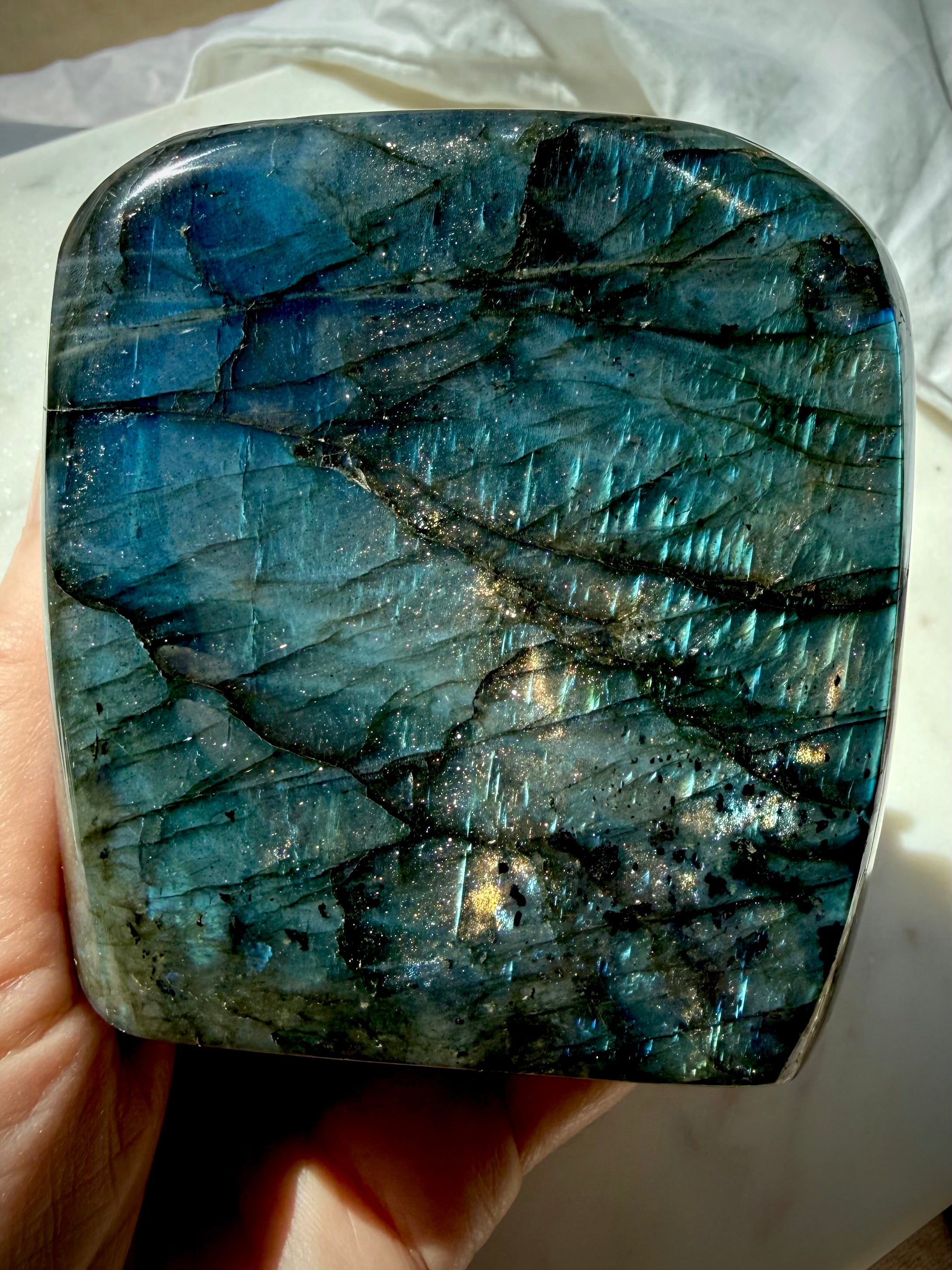 Blue Labradorite freeform showing angle-dependent aqua and electric blue flash in natural light