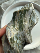Close-up of polished Green Ocean Jasper showcasing moss-green inclusions and natural layered textures.
