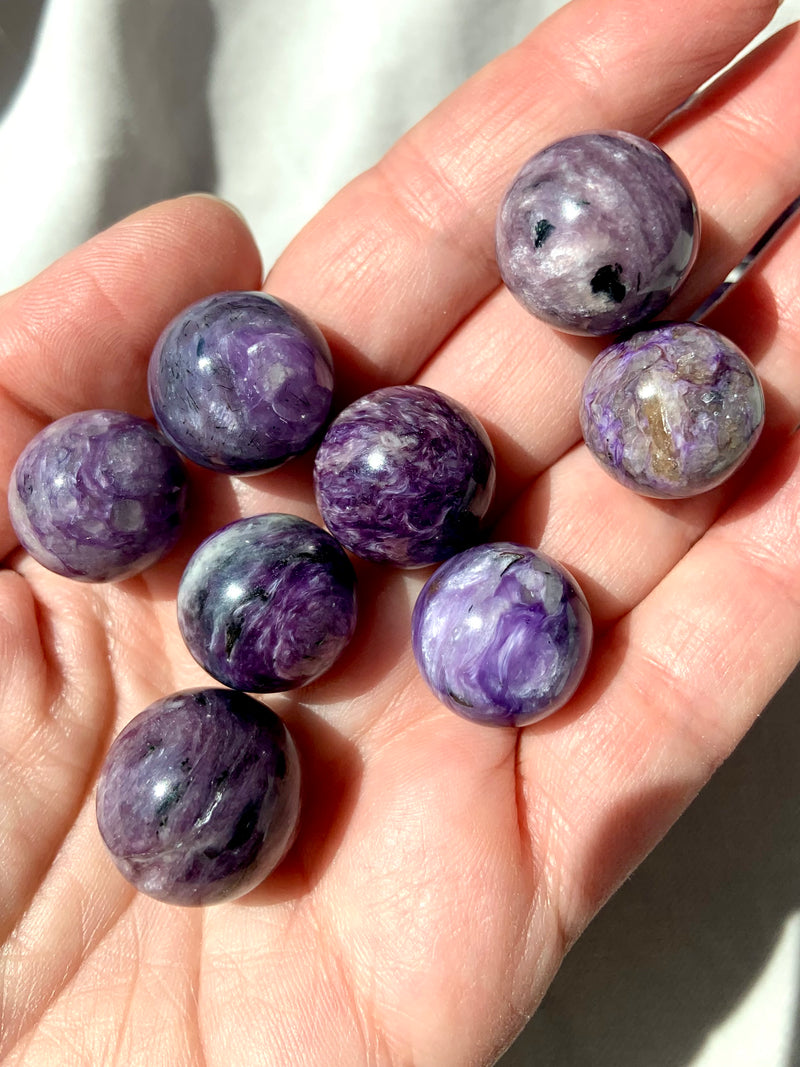 Purple Charoite mini spheres shown on my hand for scale