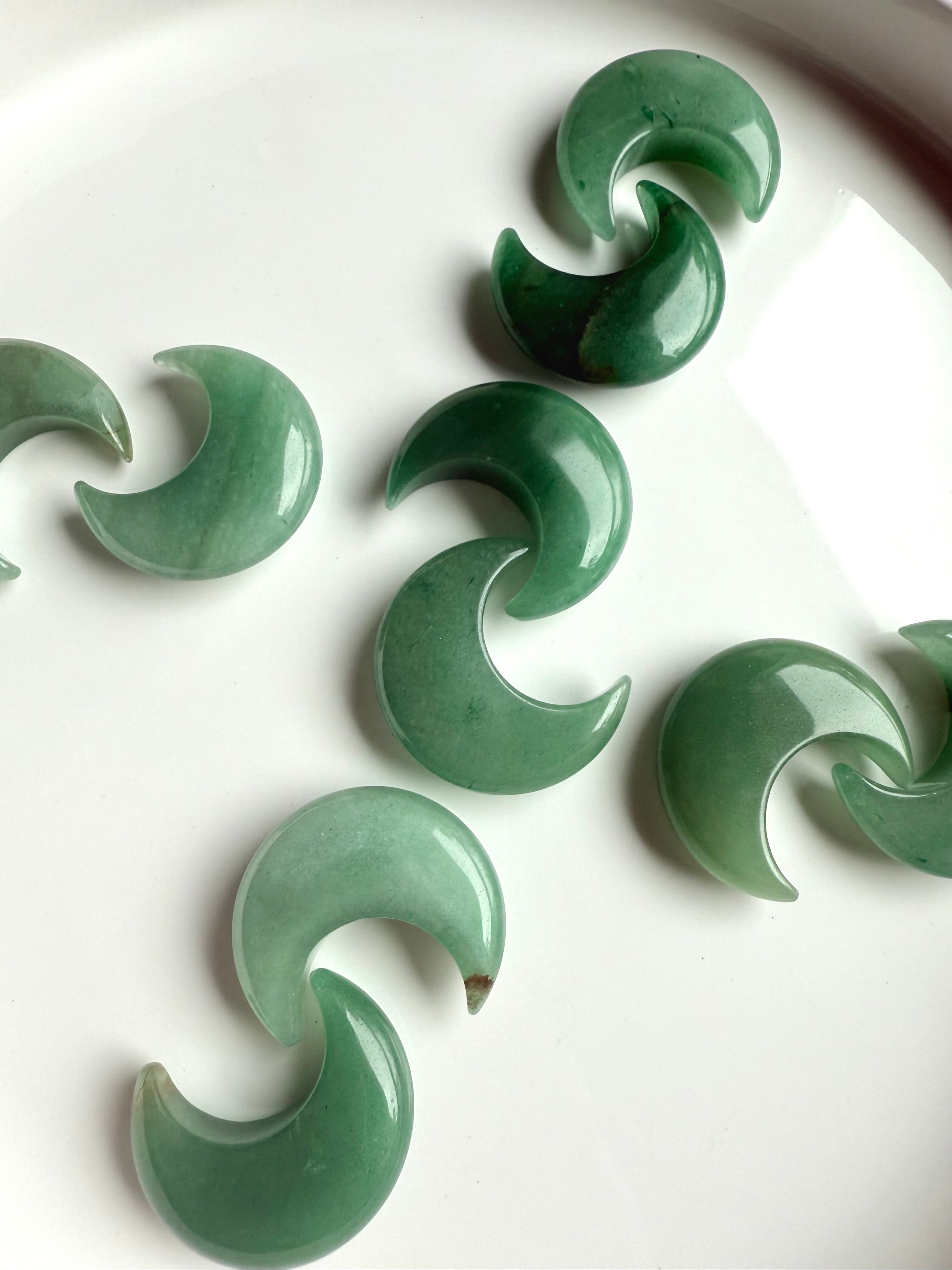 Crystal grid with Green Aventurine crescent moons in X pattern on white background, Heart Chakra stones for love and balance