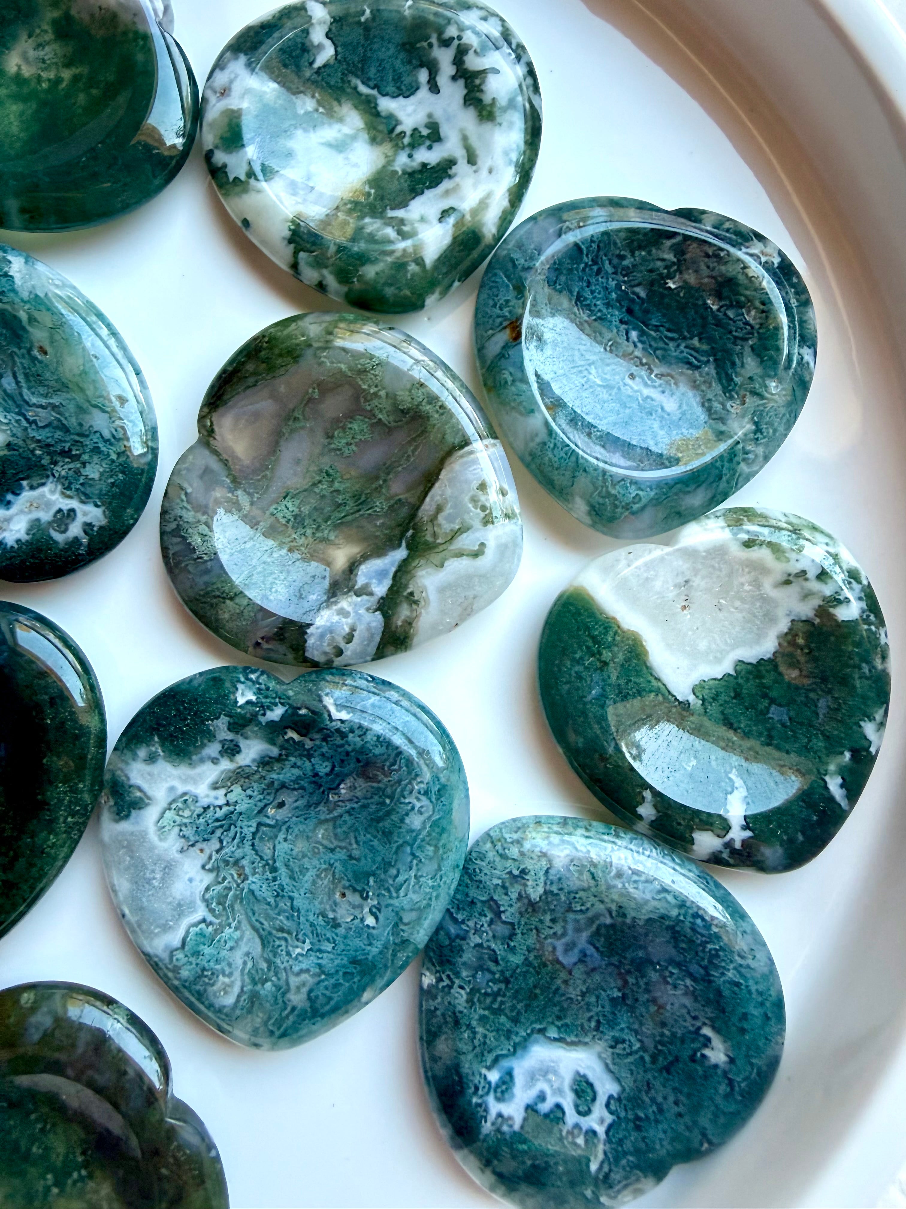Closeup of Moss Agate heart worry stones with translucent quartz, mossy green inclusions and natural landscape patterns
