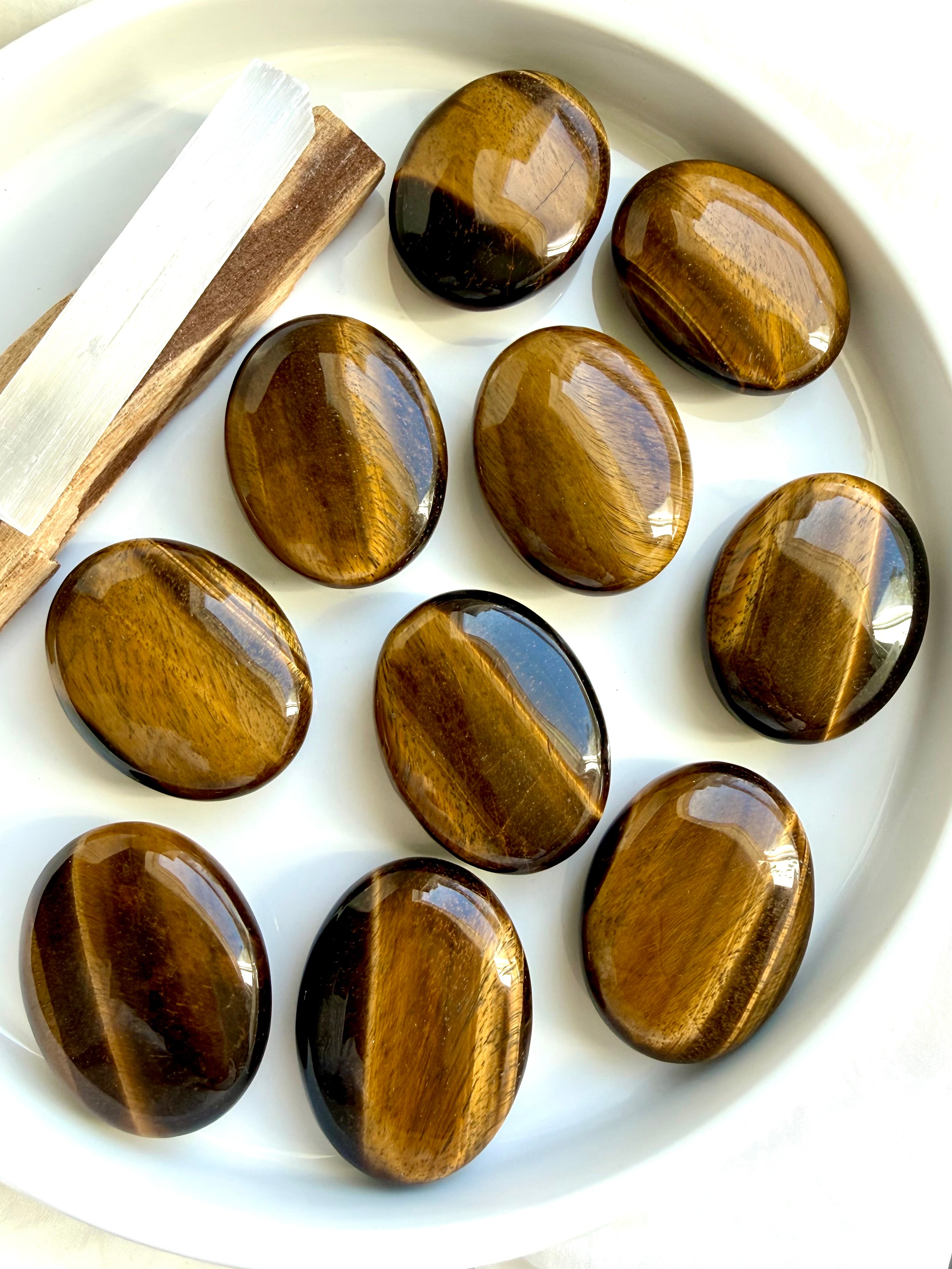 Collection of Tiger’s Eye palm stones displaying natural golden flash and silky bands of chatoyancy