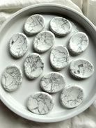 White Howlite worry stones with natural gray matrix patterns and smooth polished finish for meditation and peaceful reflection