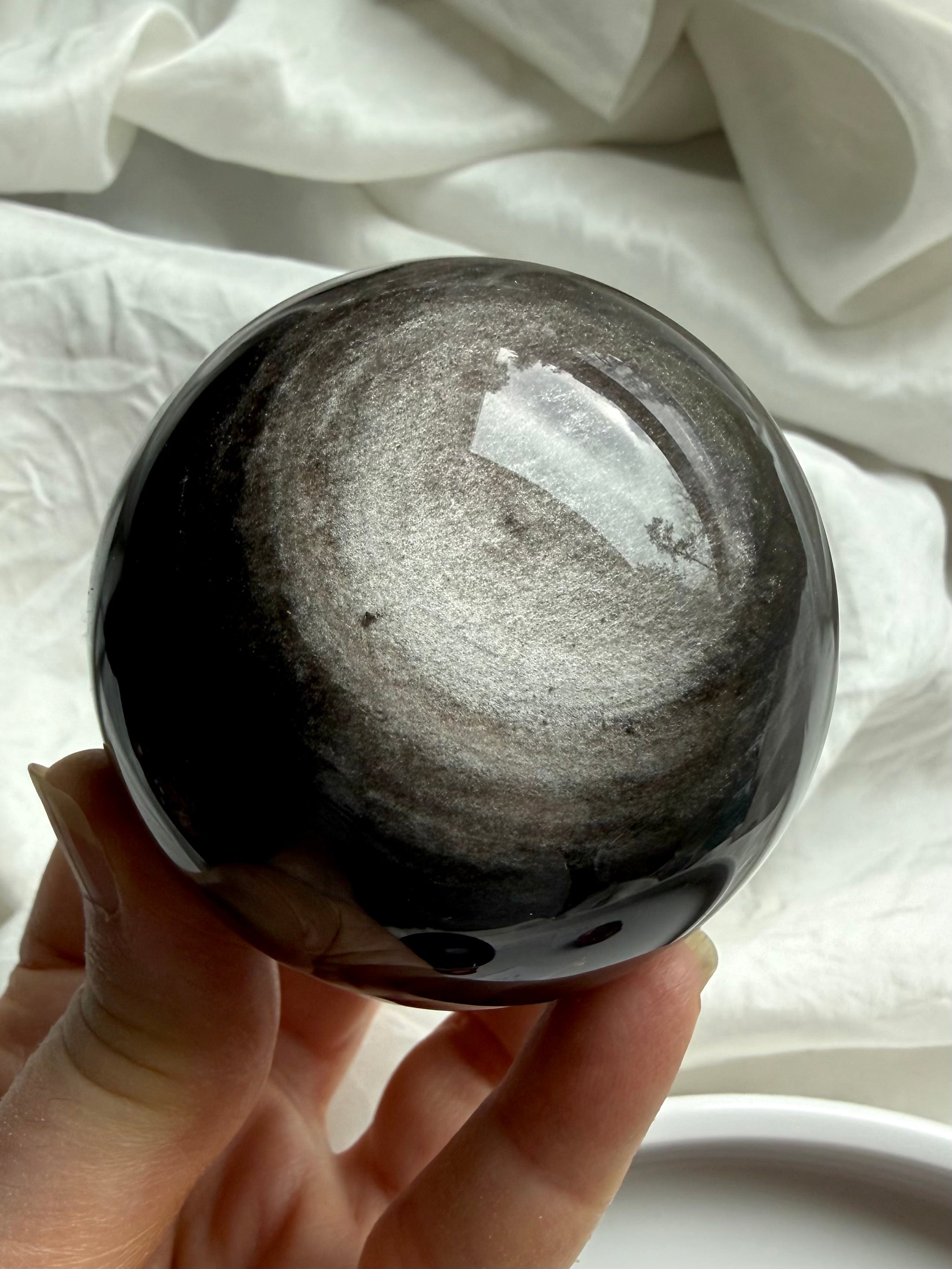 Silver Sheen Obsidian sphere held in hand, a grounding Root Chakra crystal for protection, clarity, and intuitive insight