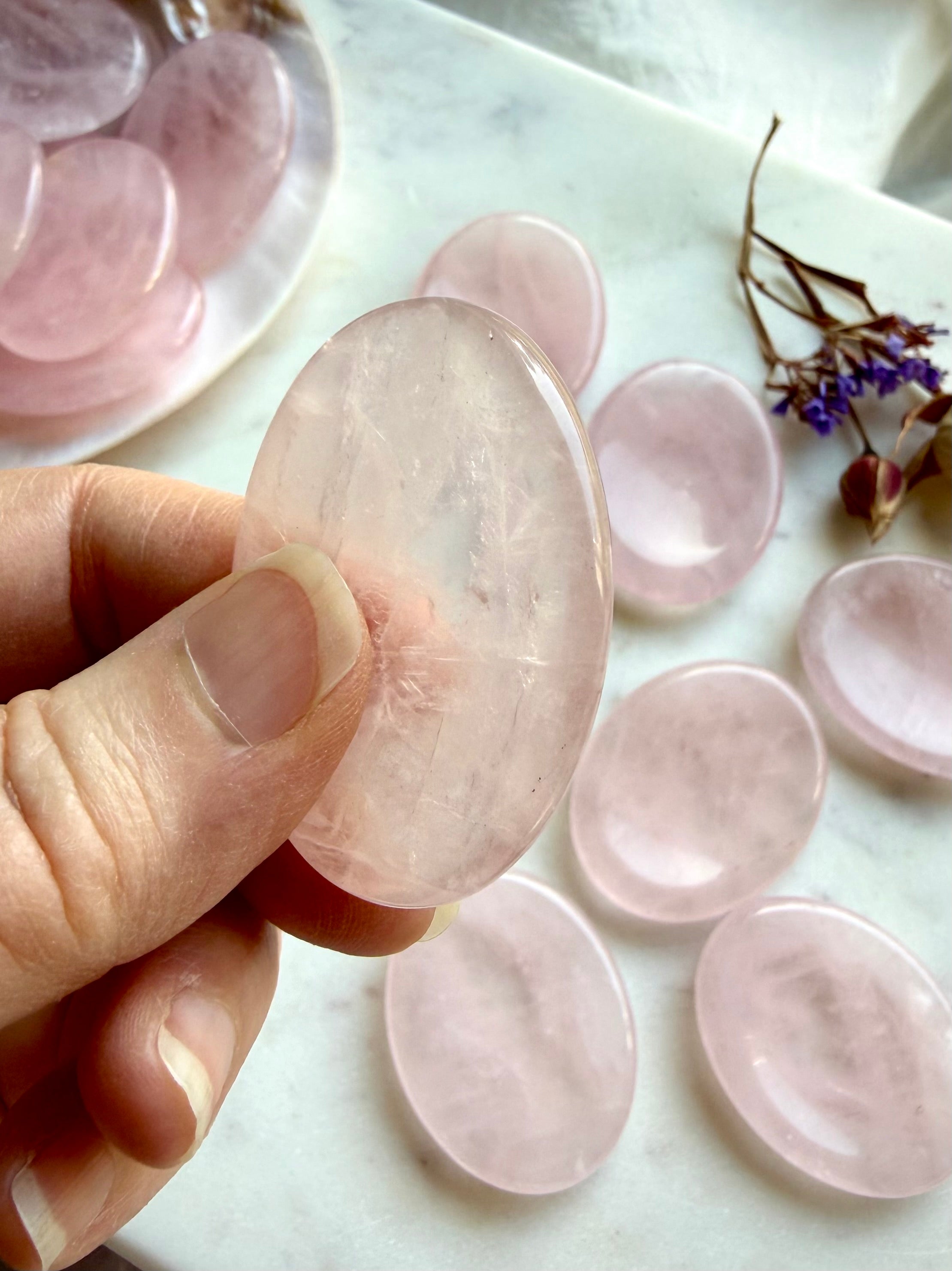 side view of rose quartz thumb stone for stress relief comfort and heart healing energy