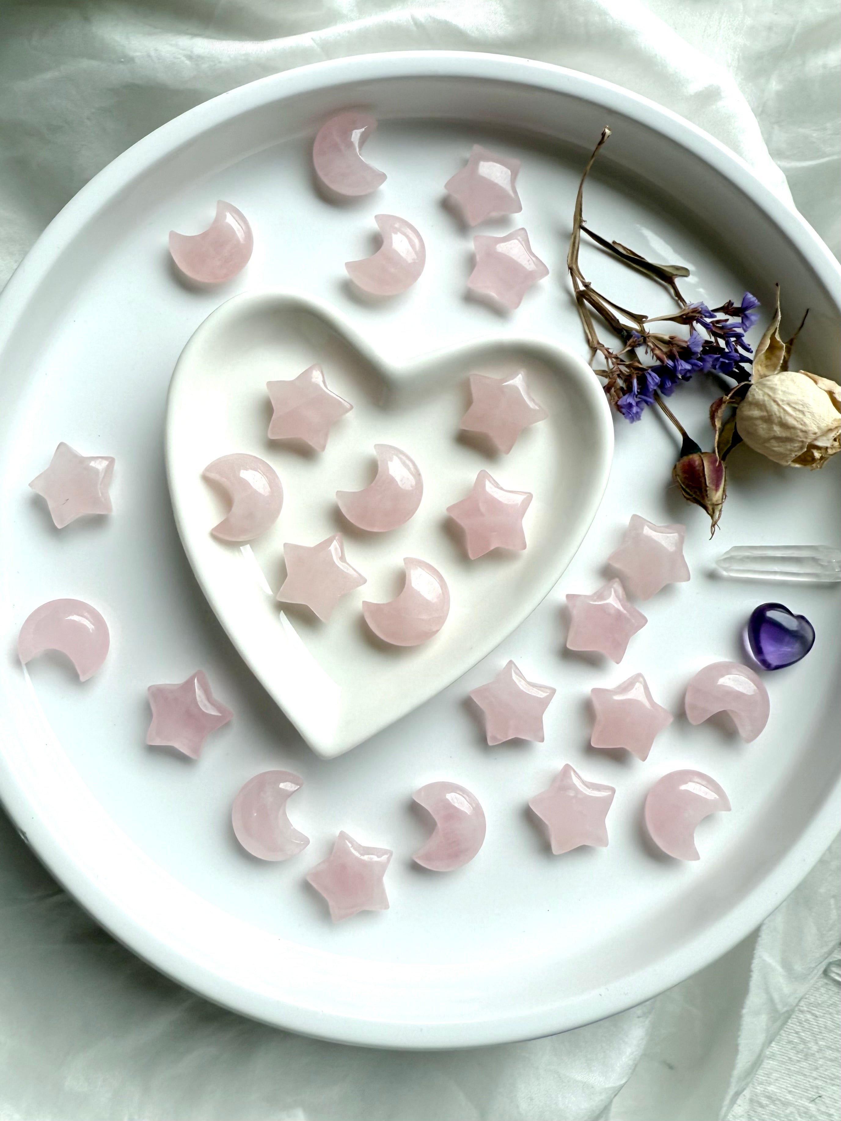 Pink Rose Quartz moons and stars on a white plate. Mini crystals for Heart Chakra healing, calm, and unconditional love.