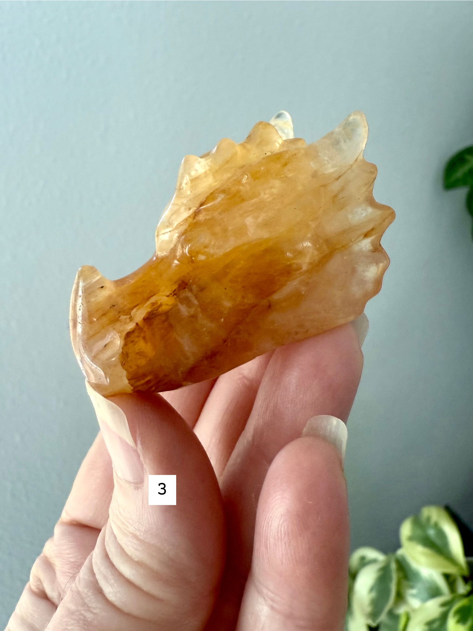 Golden Healer Quartz dragon head figurine in hand, showing detailed carving and radiant golden color — gemstone totem for meditation and altar décor.