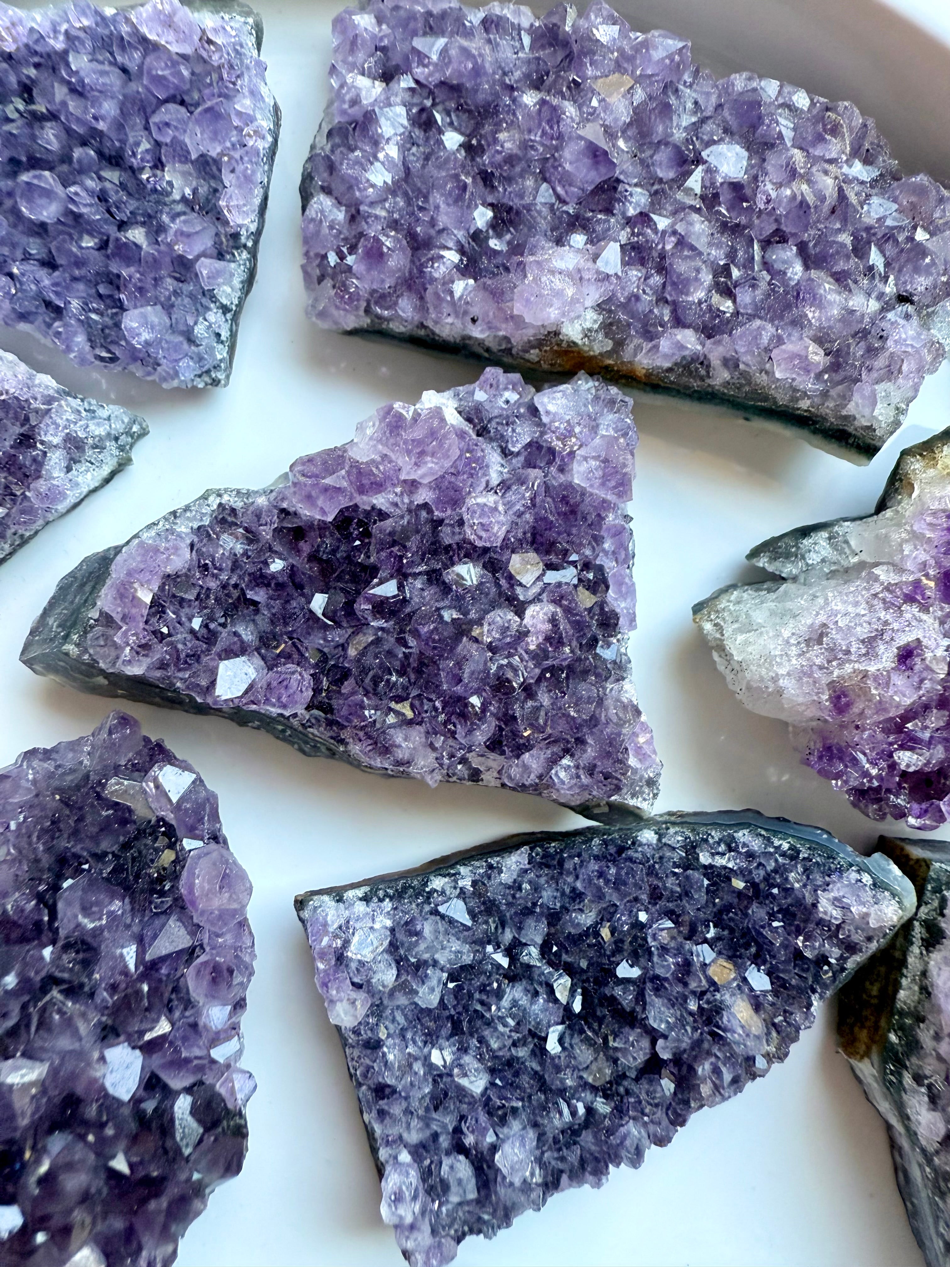 Amethyst geode clusters with raw edges and glittering purple points. Crown Chakra crystals for peace, grounding, and spiritual protection.