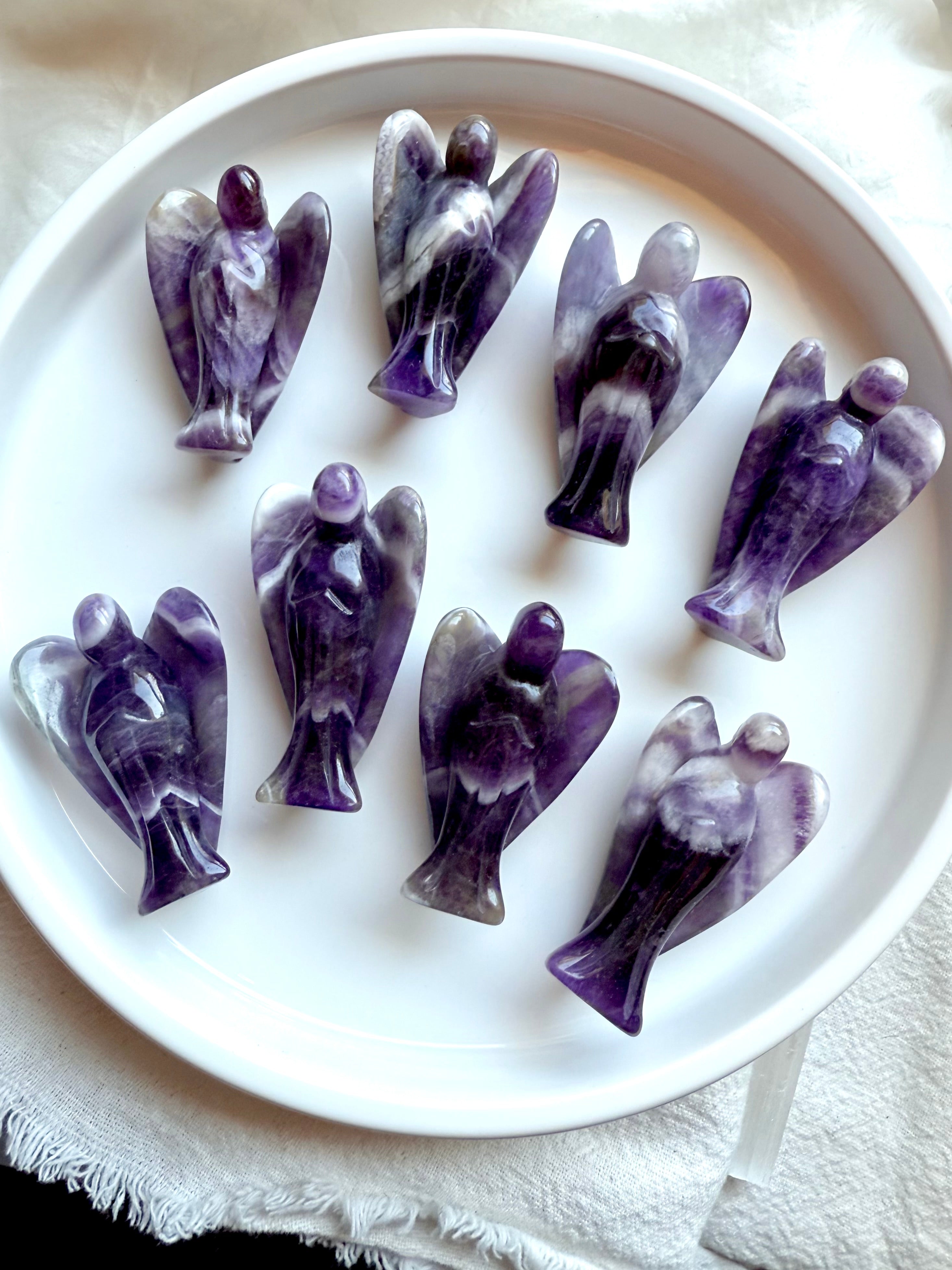 Group of eight hand-carved Dream Amethyst angel crystals from Zambia, showcasing bold Chevron Amethyst banding for peace, clarity, and spiritual protection.