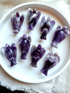 Group of eight hand-carved Dream Amethyst angel crystals from Zambia, showcasing bold Chevron Amethyst banding for peace, clarity, and spiritual protection.