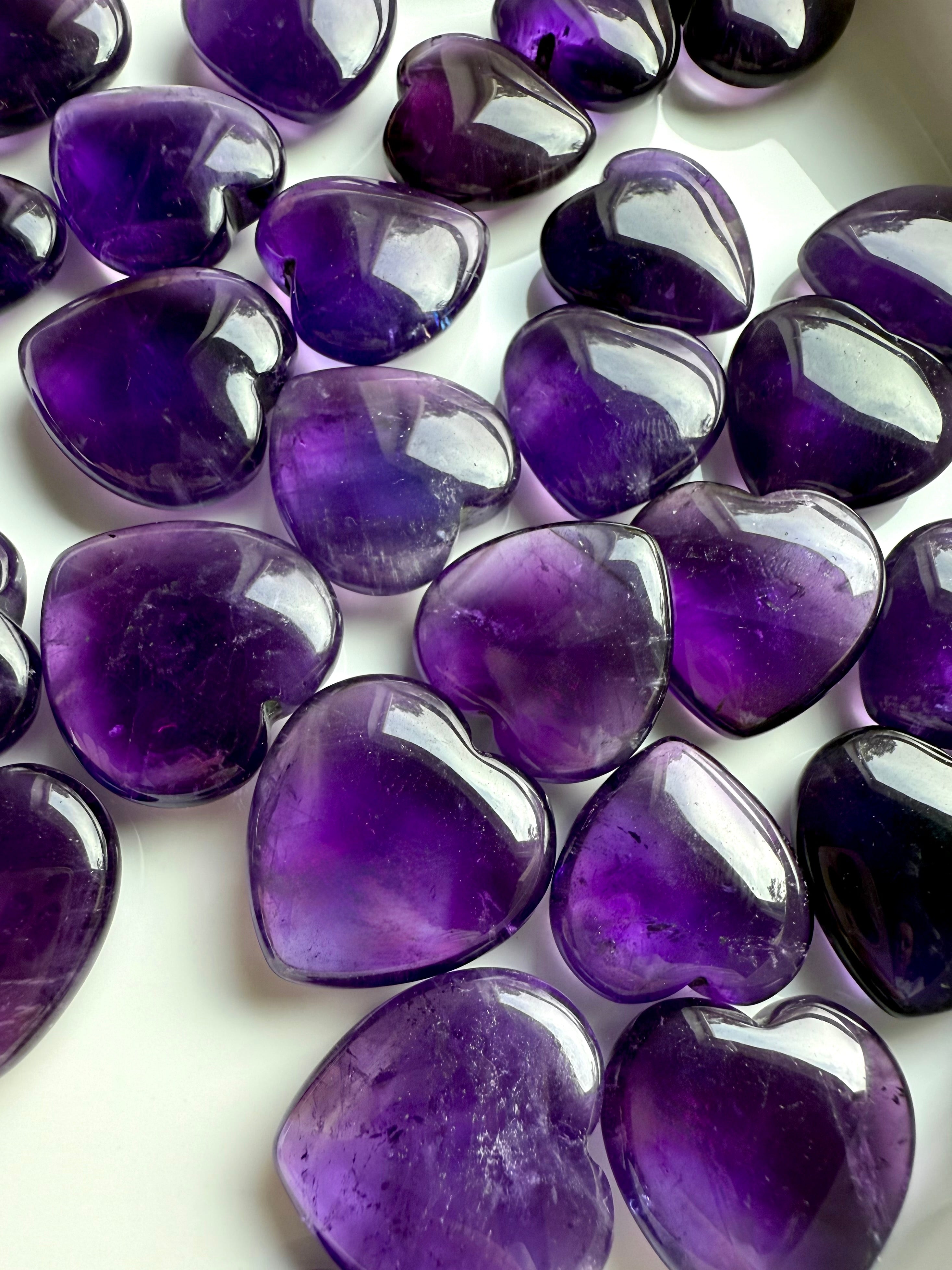 Assorted Amethyst crystal hearts with rich violet color and natural inclusions — healing crystals for spiritual clarity, intuition, and crown chakra alignment