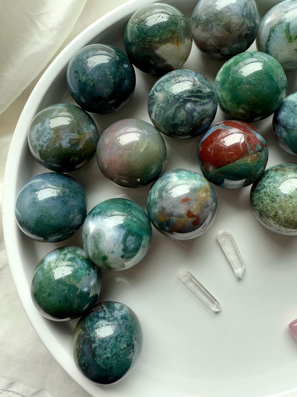 Colorful moss agate mini spheres shown on a white plate