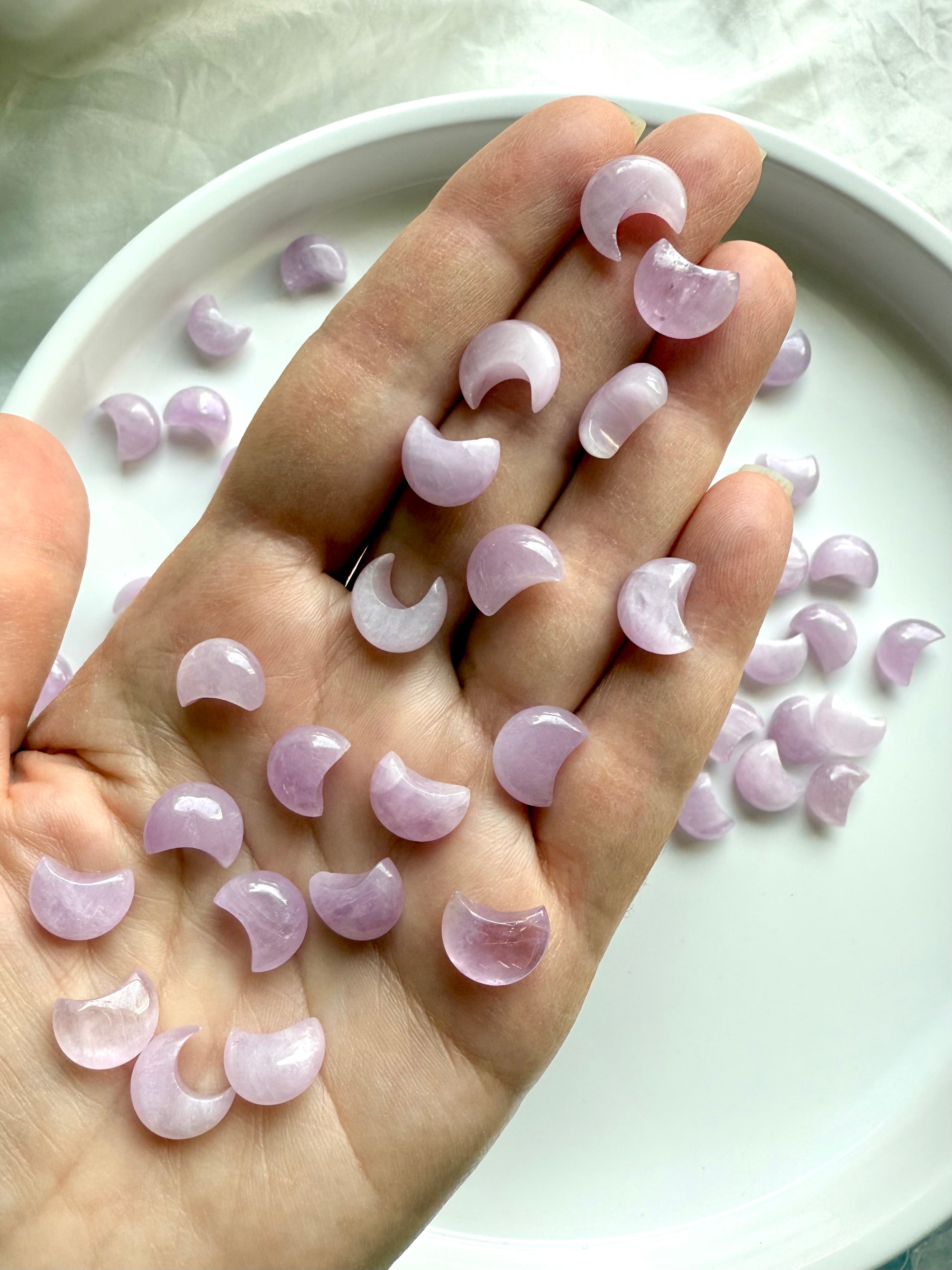 Mini Kunzite moon carvings shown in hand — small crystal moons for love, compassion & heart chakra support.