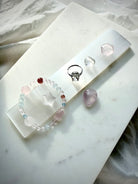 White Selenite charging wand displayed with small crystals and jewelry for crystal cleansing, charging and energy purification rituals
