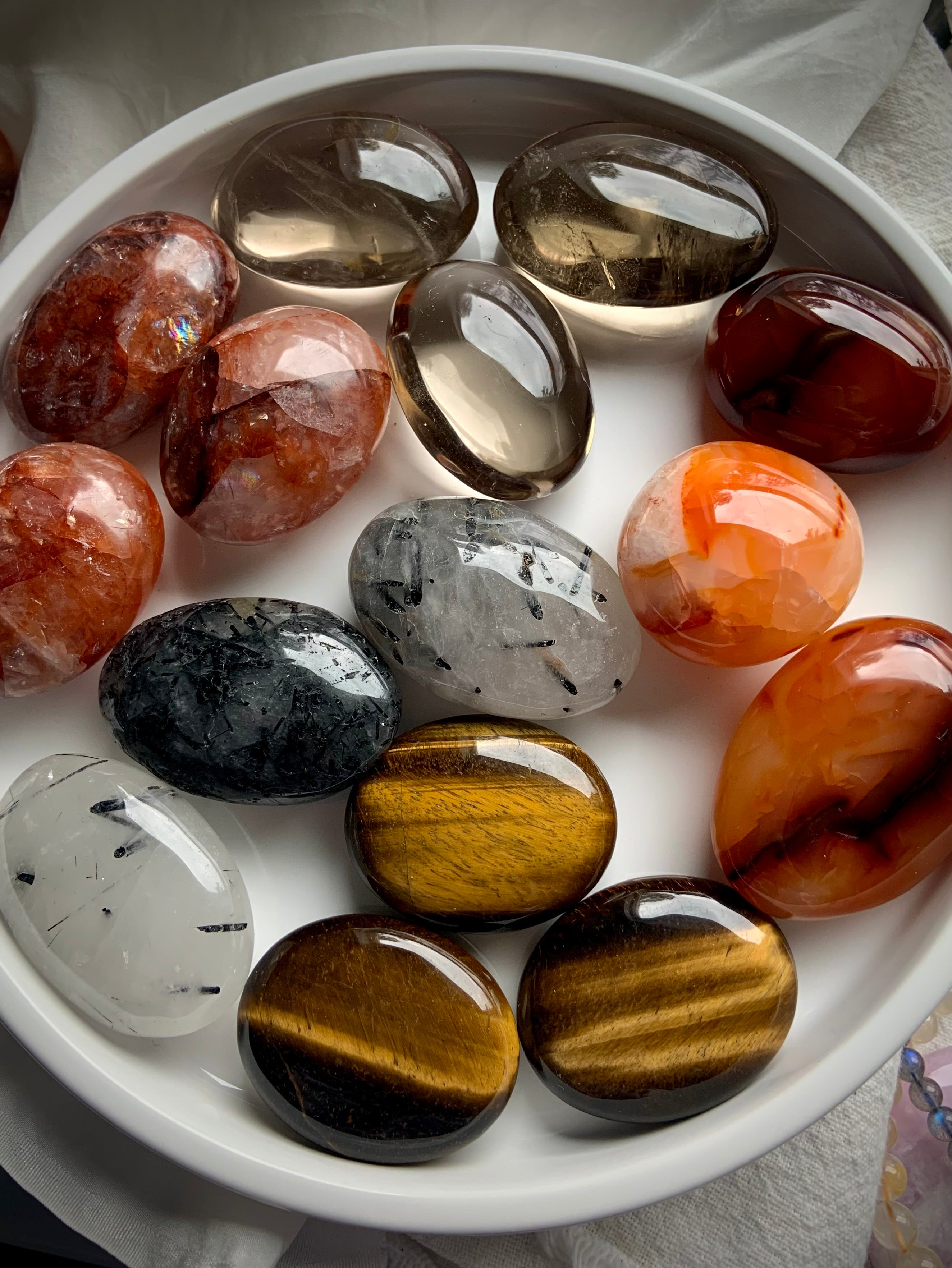 Full plate of chakra crystal palm stones in rich earthy tones — tumbled stones for grounding, energy alignment &amp; spiritual empowerment.