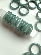 Rounded Blue Water jade rings arranged on white surface, natural Guatemalan jadeite bands