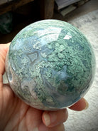 Druzy Moss Agate sphere showing polished crystal details, Quartz veins, and earthy green inclusions