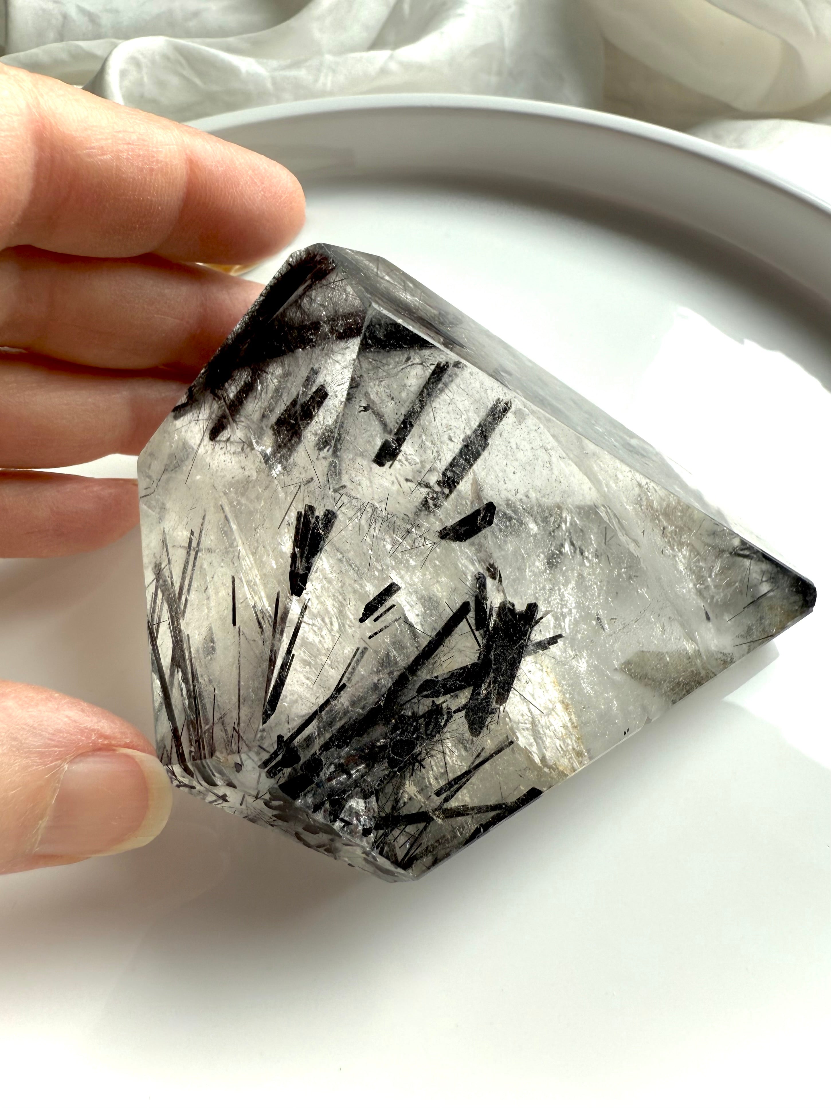 Black Tourmaline in Quartz freeform crystal styled on white plate with soft natural light