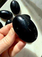 Black Obsidian palm stone with natural mineral inclusions, polished volcanic glass crystal for grounding and energetic protection