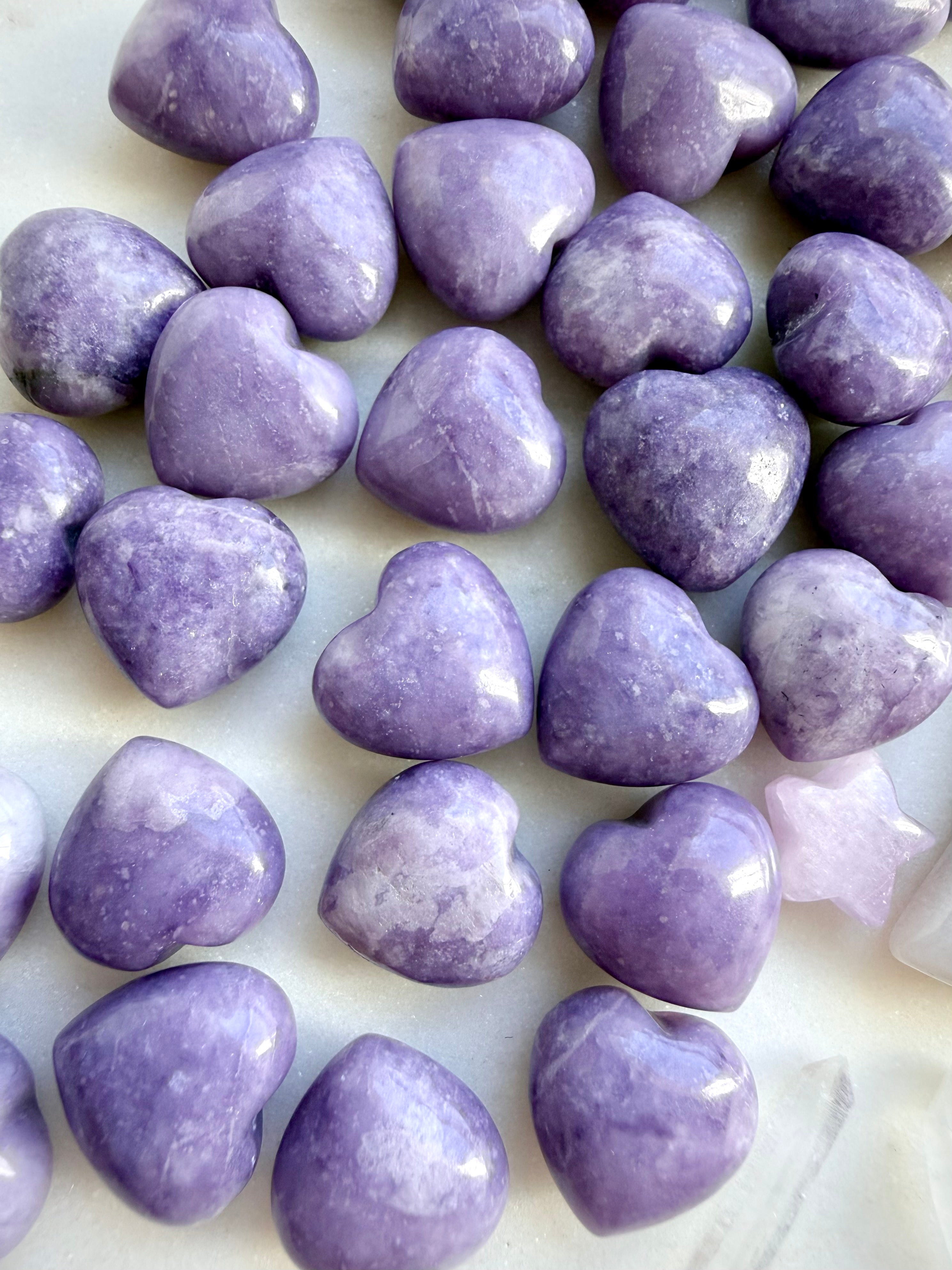 Closeup of Mini Lilac Lepidolite crystal hearts with soft lavender and violet tones