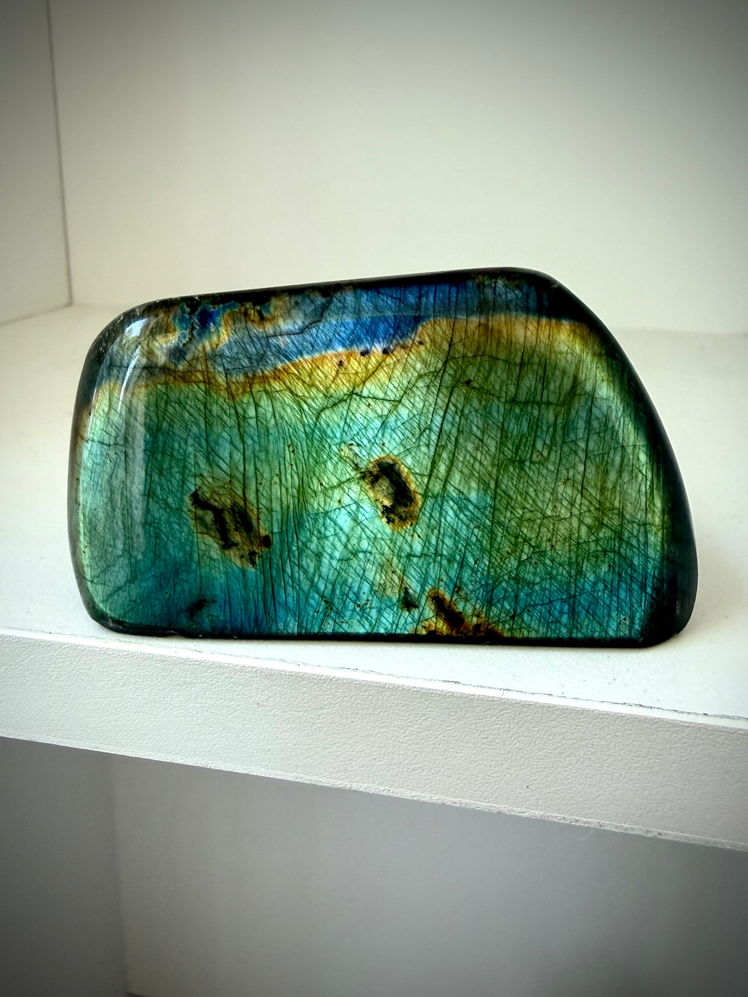 Polished Labradorite freeform with teal green and gold flash displayed upright