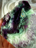 Close-up of green and purple fluorite slab showing rainbow internal flashes and white scolecite snowflake inclusions