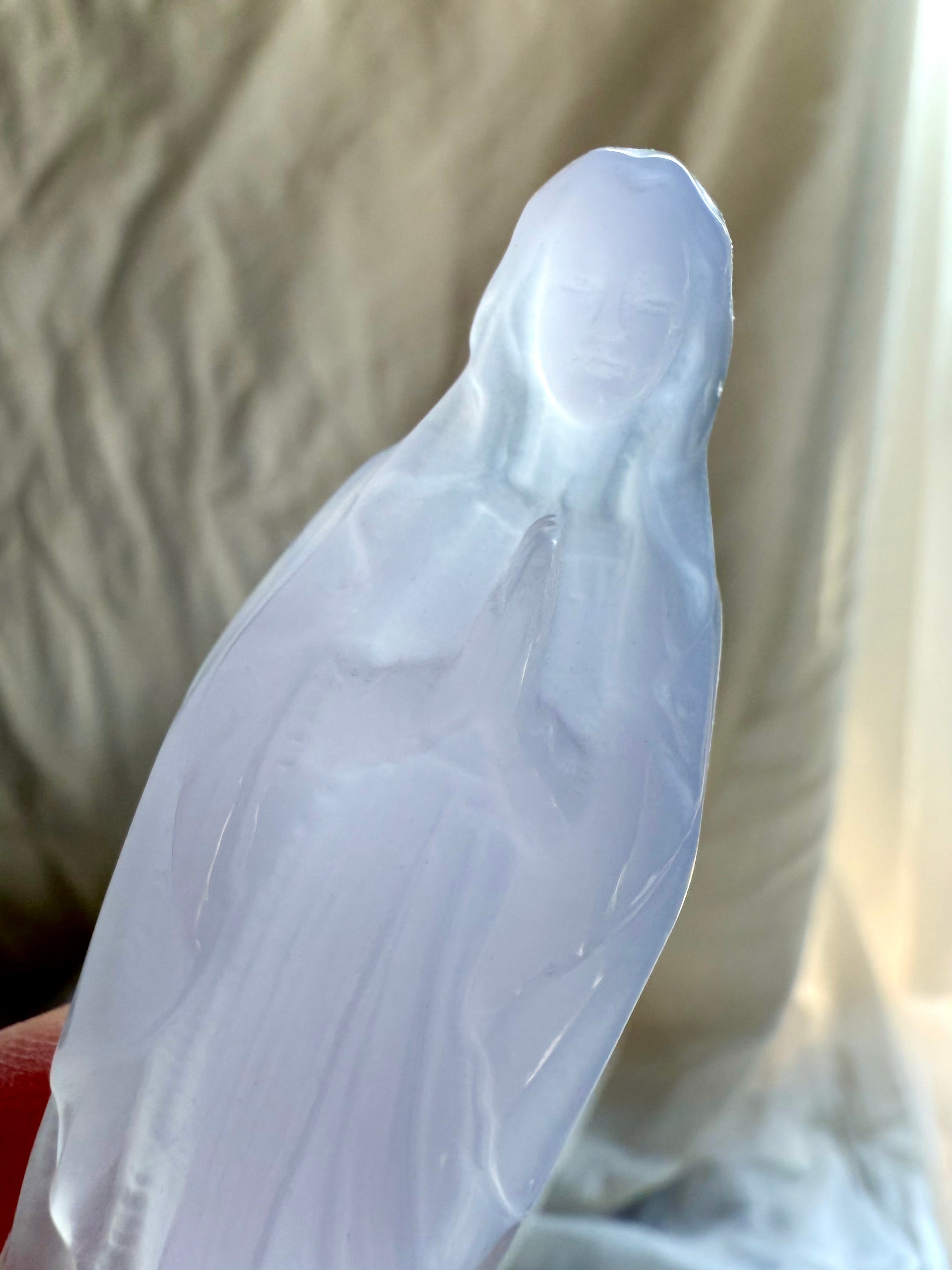Close view of Lavender Fluorite Mother Mary carving with hands held in prayer over her heart