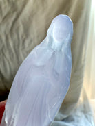 Close view of Lavender Fluorite Mother Mary carving with hands held in prayer over her heart