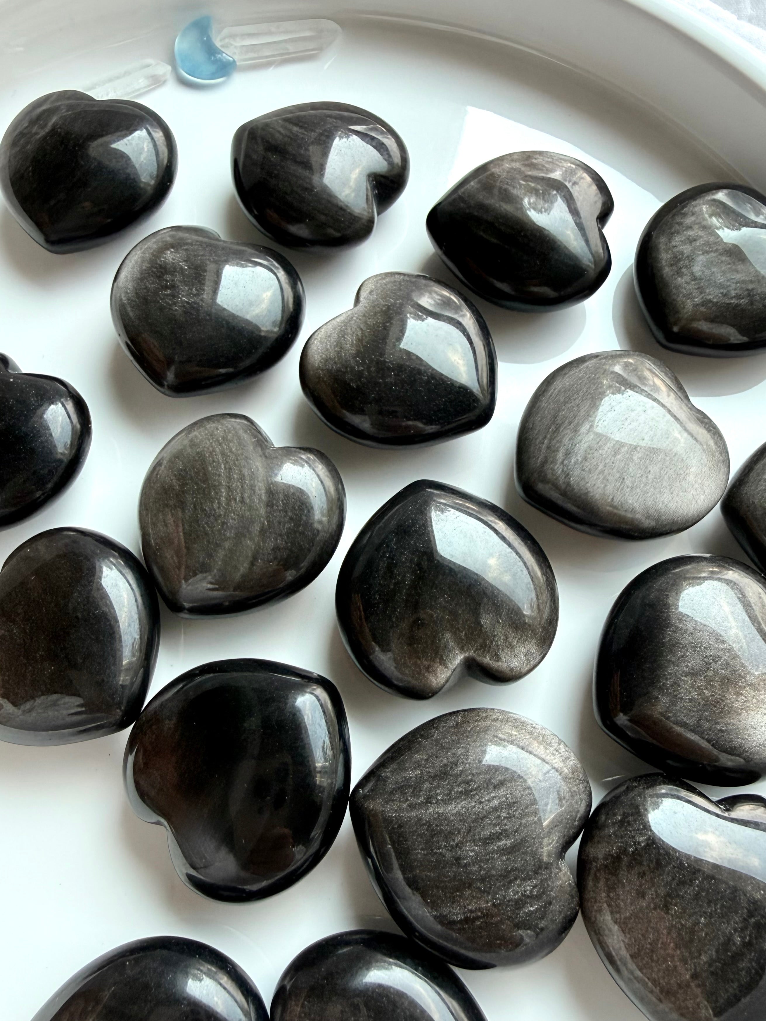 Polished Obsidian heart crystals showing variations from deep black to silvery charcoal sheen
