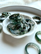moss agate band rings styled together showing natural dendritic inclusions and polished shine, grounding crystal rings for everyday wear