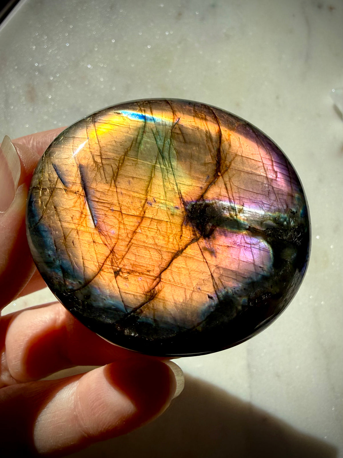 Labradorite palm stone with intense golden rainbow flash accented by green, blue, pink and purple labradorescence