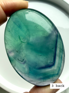 Teal fluorite palm stone #3 back view showing layered blue green banding and natural inclusions