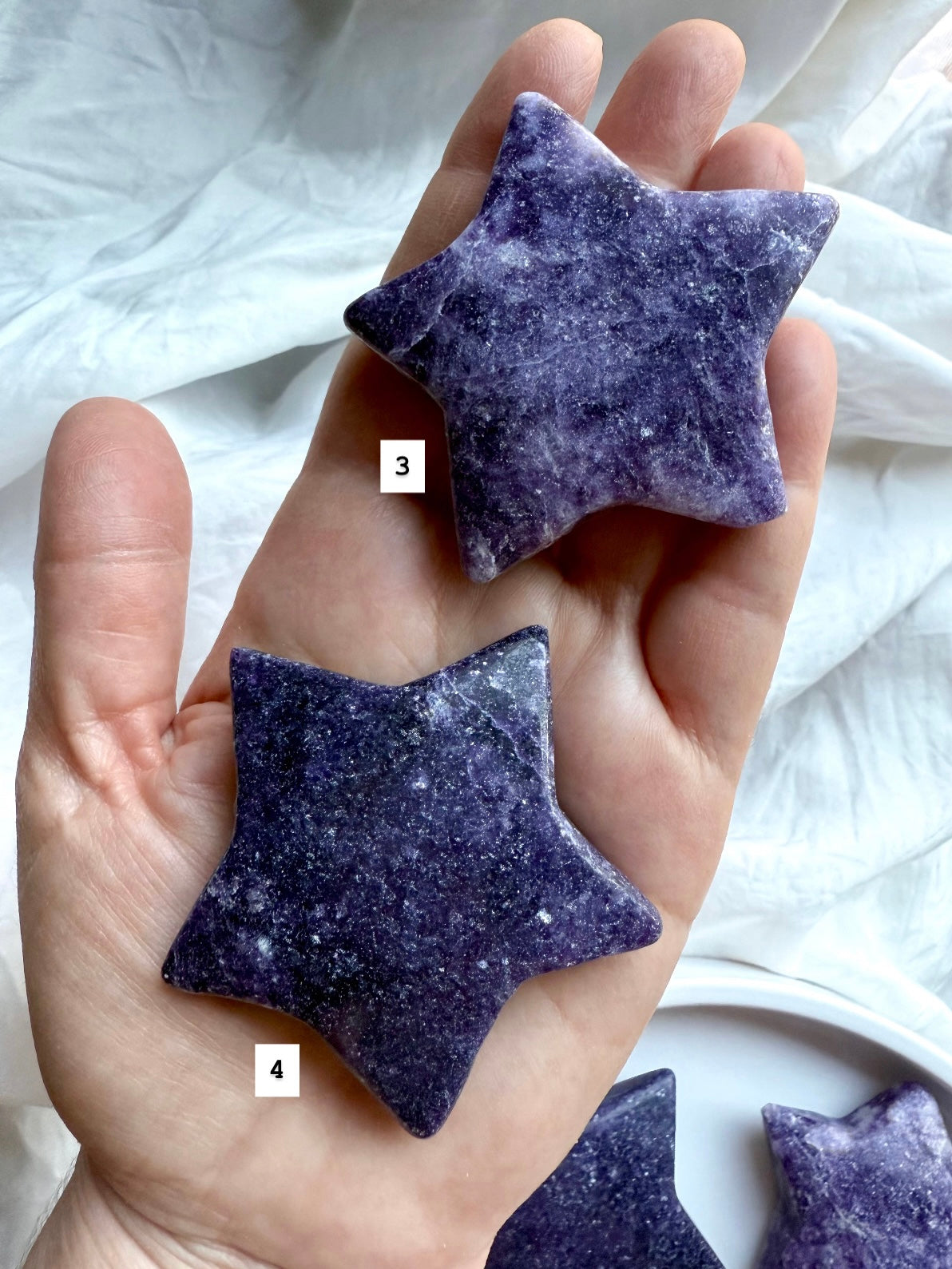 Hand holding two Lepidolite chunky star crystals, numbered for selection, purple and lavender polished carvings for emotional healing.
