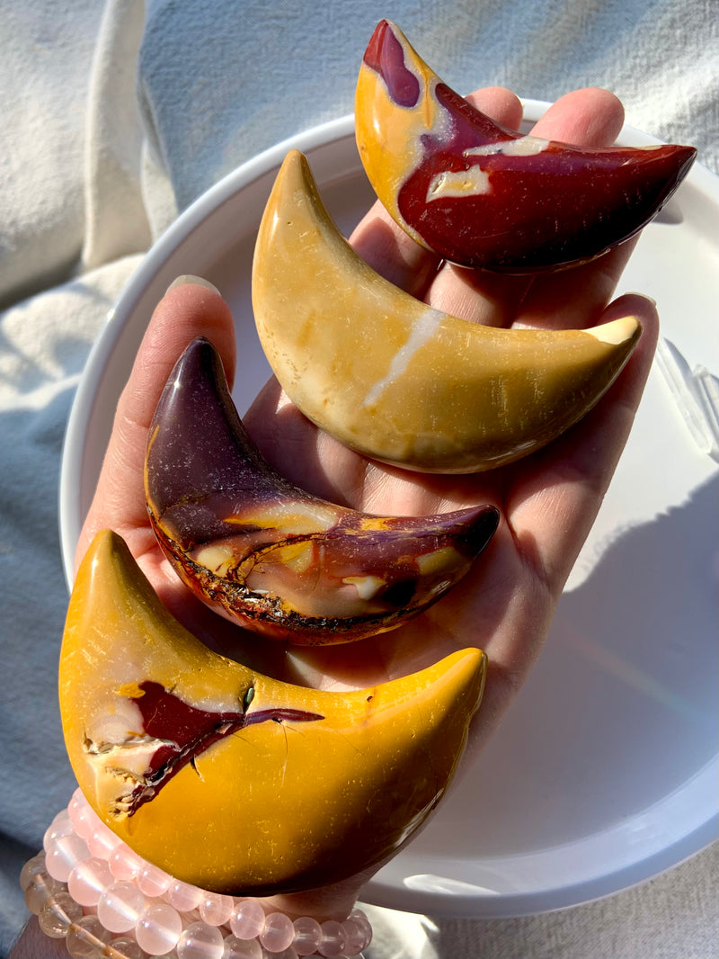 Big, colorful Mookaite Jasper Crescent Moon Carvings shown on my hand for scale. Choose your favorite from the dropdown menu.