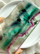 Polished fluorite slab photographed in natural light highlighting green and purple crystal banding
