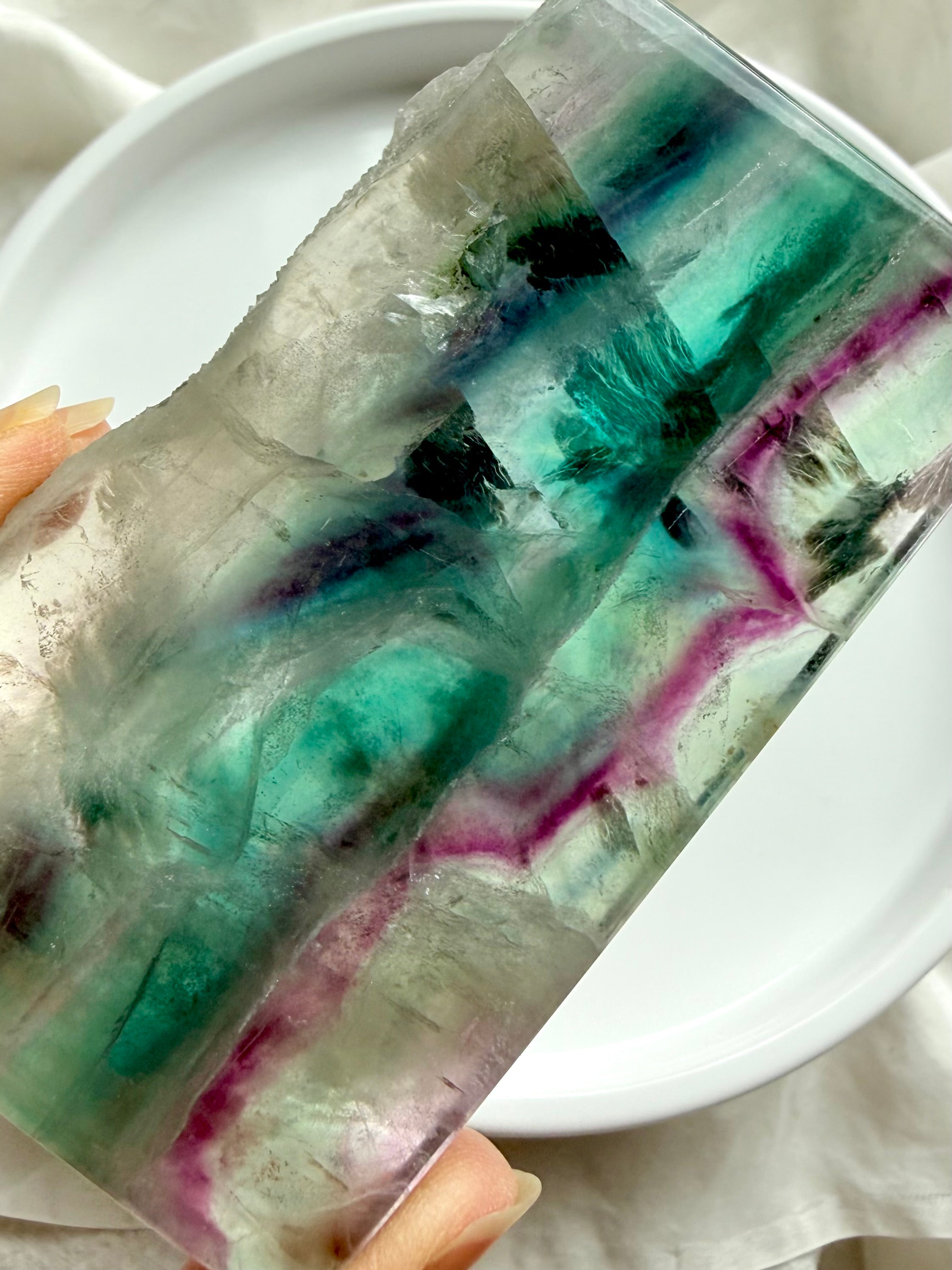 Polished fluorite slab photographed in natural light highlighting green and purple crystal banding