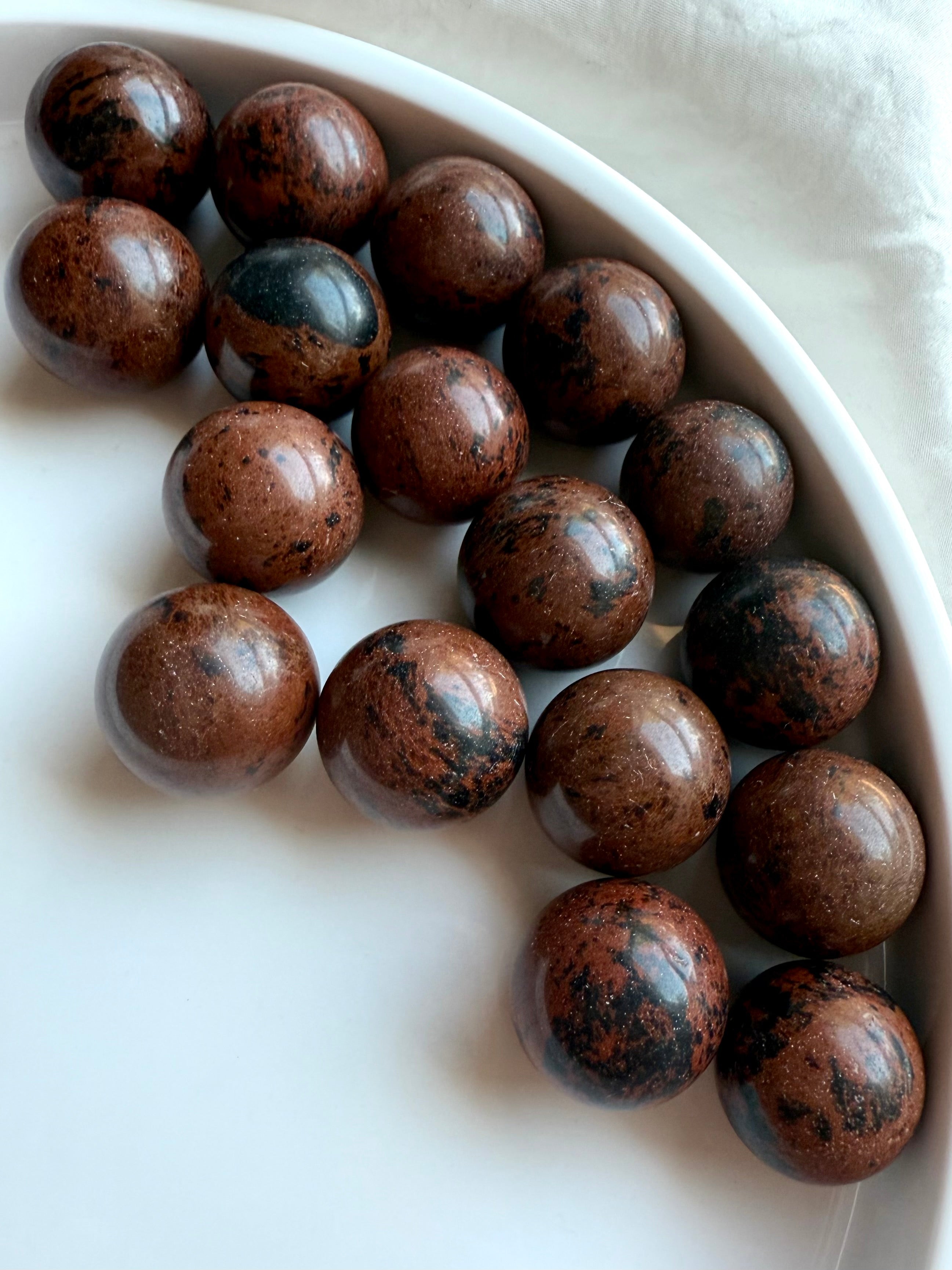 Array of Mahogany Obsidian mini spheres with rich brown and black patterns – crystals for protection and strength