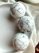Howlite crystal spheres in white bowl with natural gray veining, polished calming stone spheres for sleep, anxiety relief and peaceful home décor