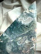 Macro detail of moss agate flame with icy blue-green tones, lace agate banding and crystal druzy sparkle