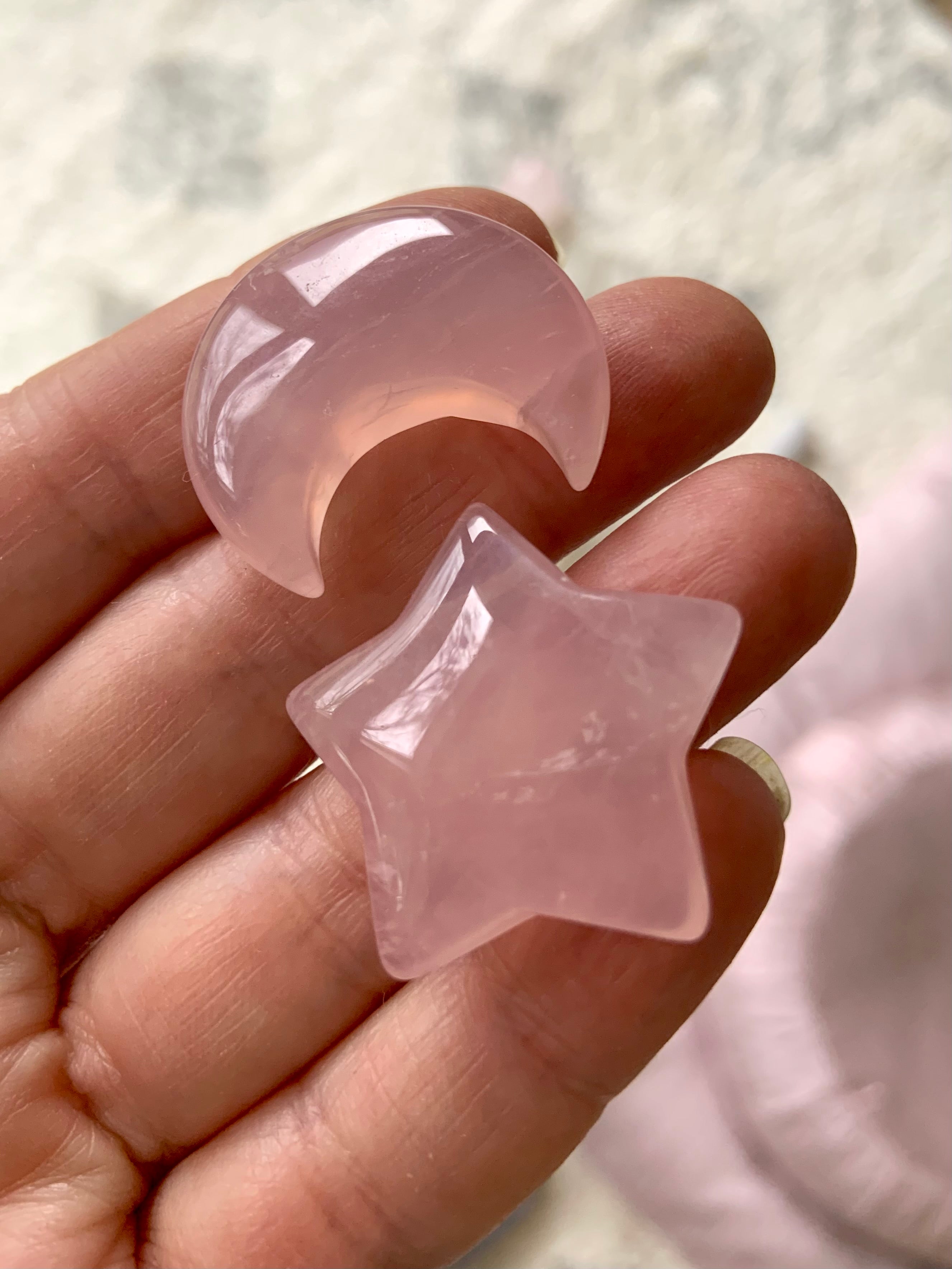 Close-up of Rose quartz moon and star crystals shown in hand for scale. Heart Chakra stones perfect for meditation or gifting.