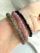 Crystal bracelet stack featuring Lavender Rose Quartz, Black Moonstone, and faceted Black Spinel gemstone bracelets