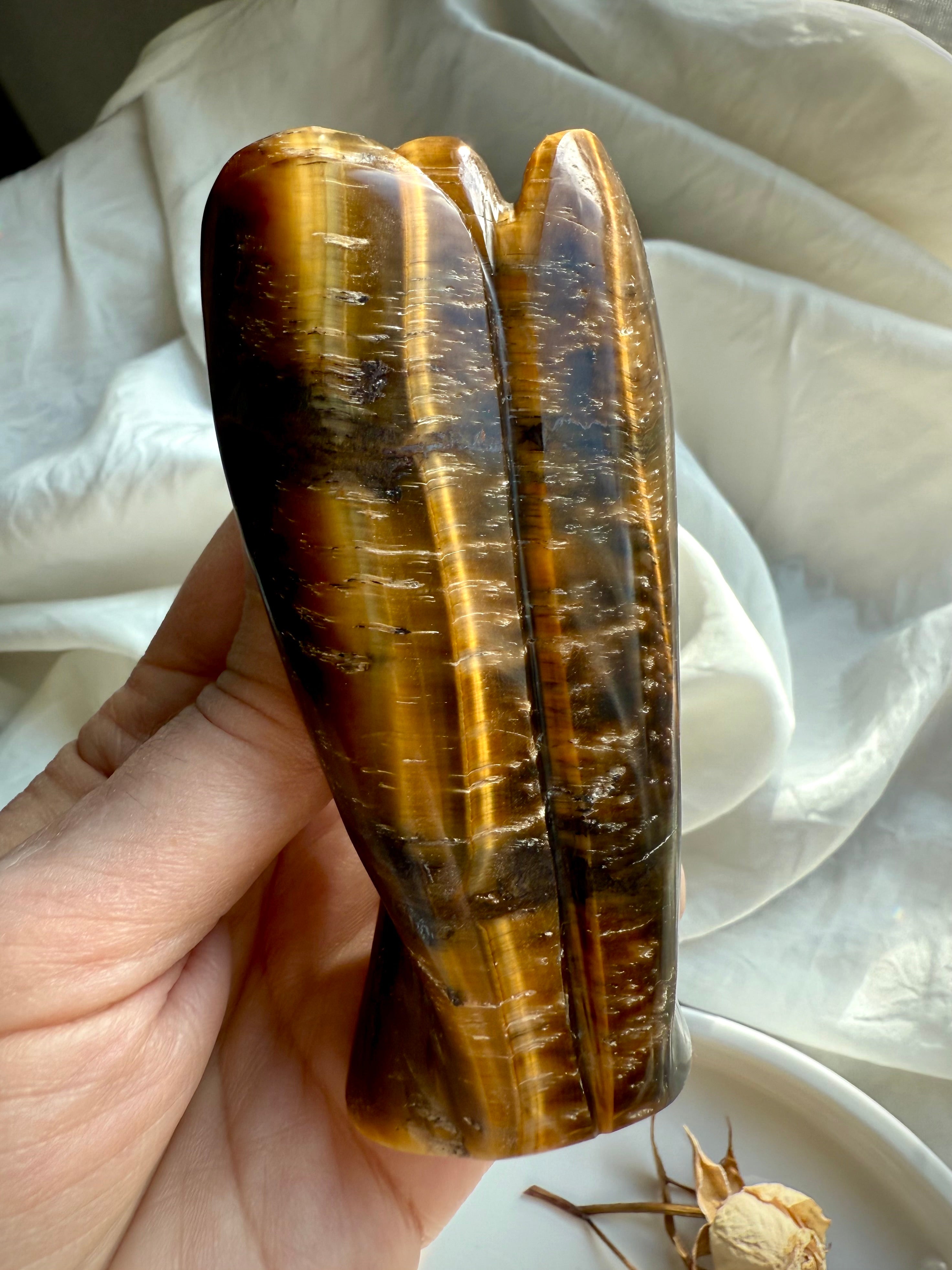 Back view of hand-carved Tiger’s Eye angel showing natural golden bands and reflective sheen