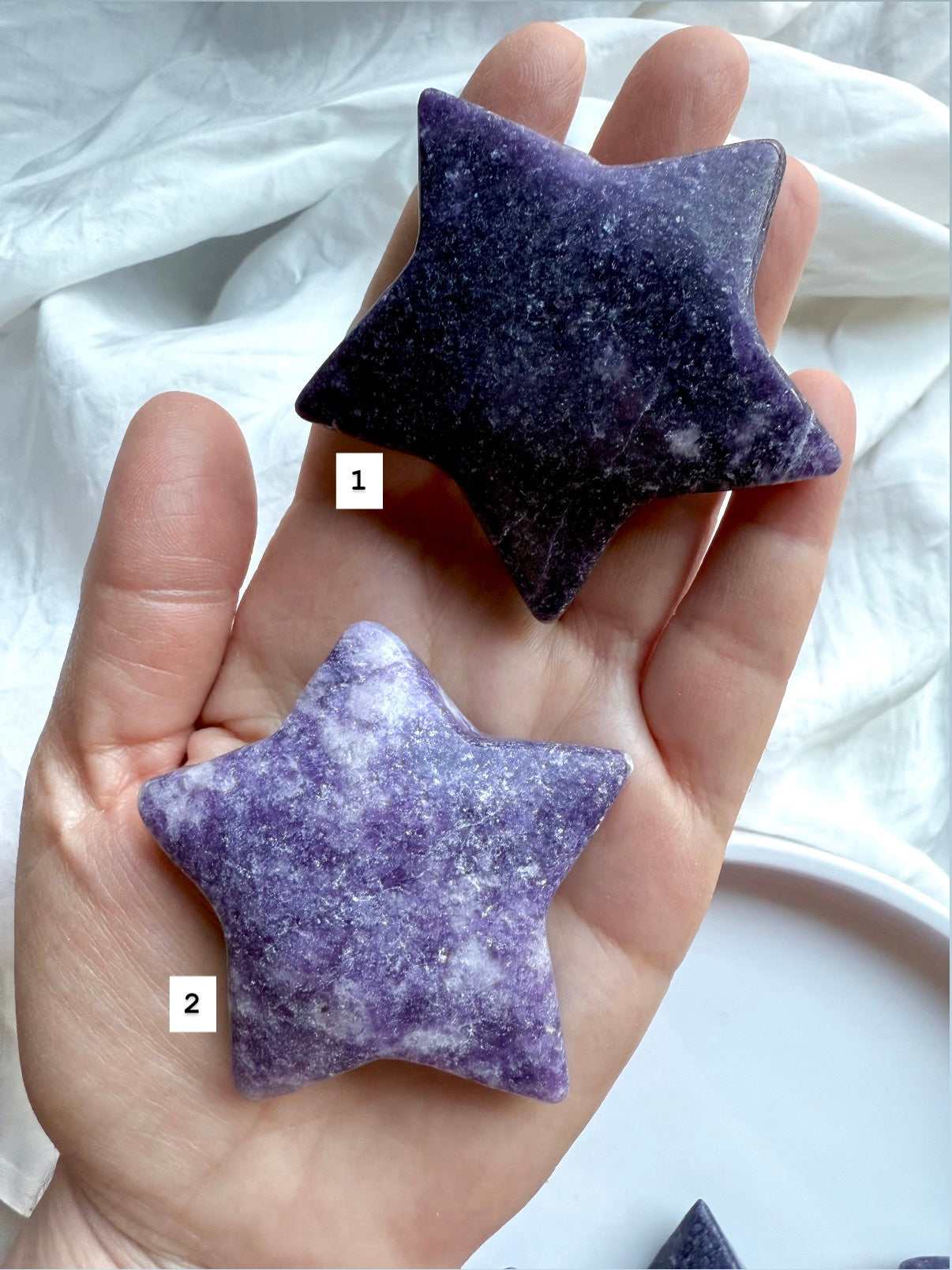 Hand holding two Lepidolite chunky star crystals, numbered for selection, purple and lavender polished carvings for emotional healing.