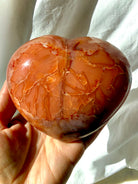 Large one of a kind Carnelian geode heart crystal shown in hand for size reference