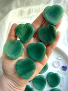 group of green aventurine heart worry stones held in hand, polished pocket crystals for prosperity and new beginnings