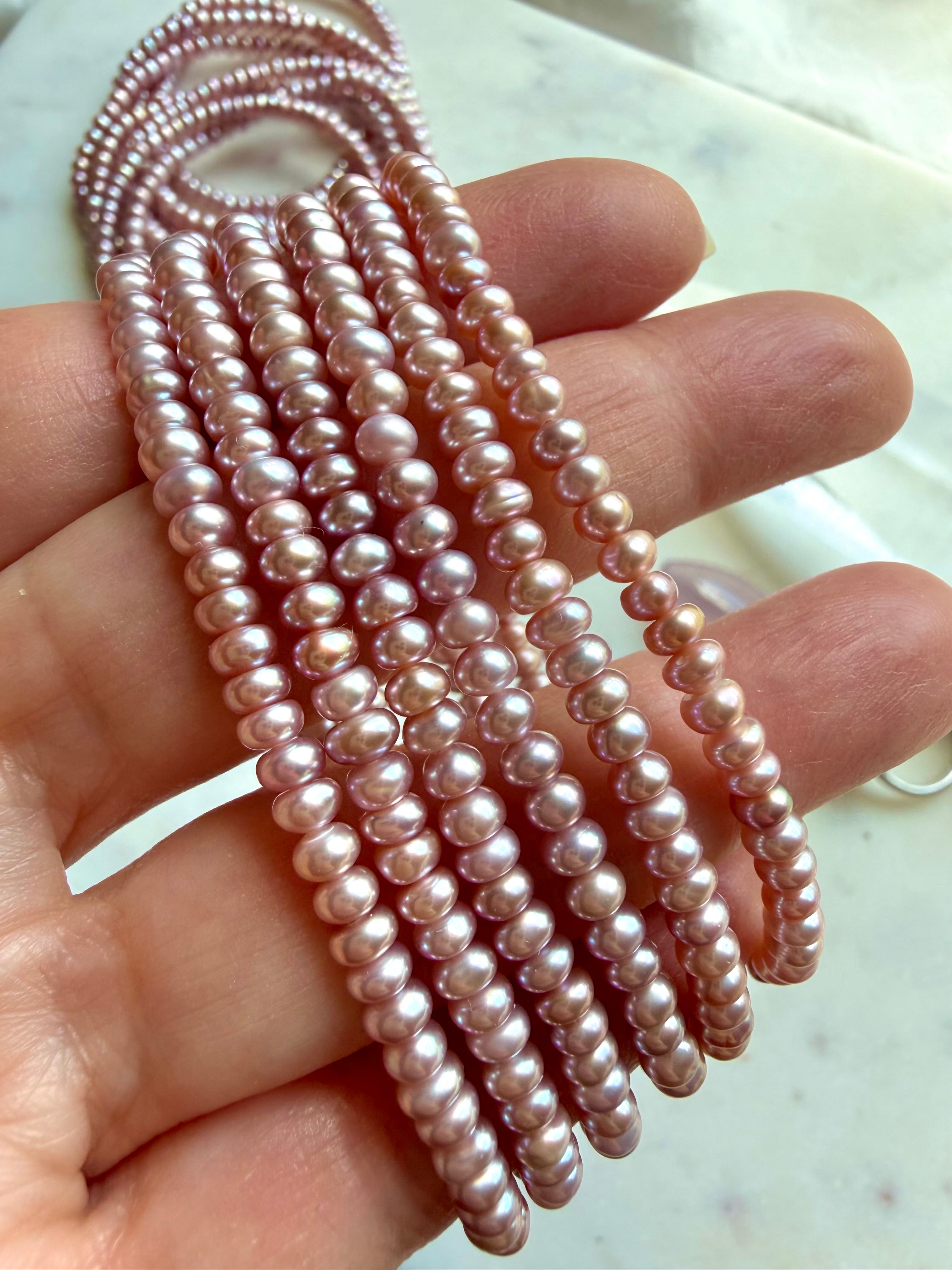 pink pearl bracelets bundle held in hand, freshwater pearl jewelry with silvery lilac glow and organic bead shapes