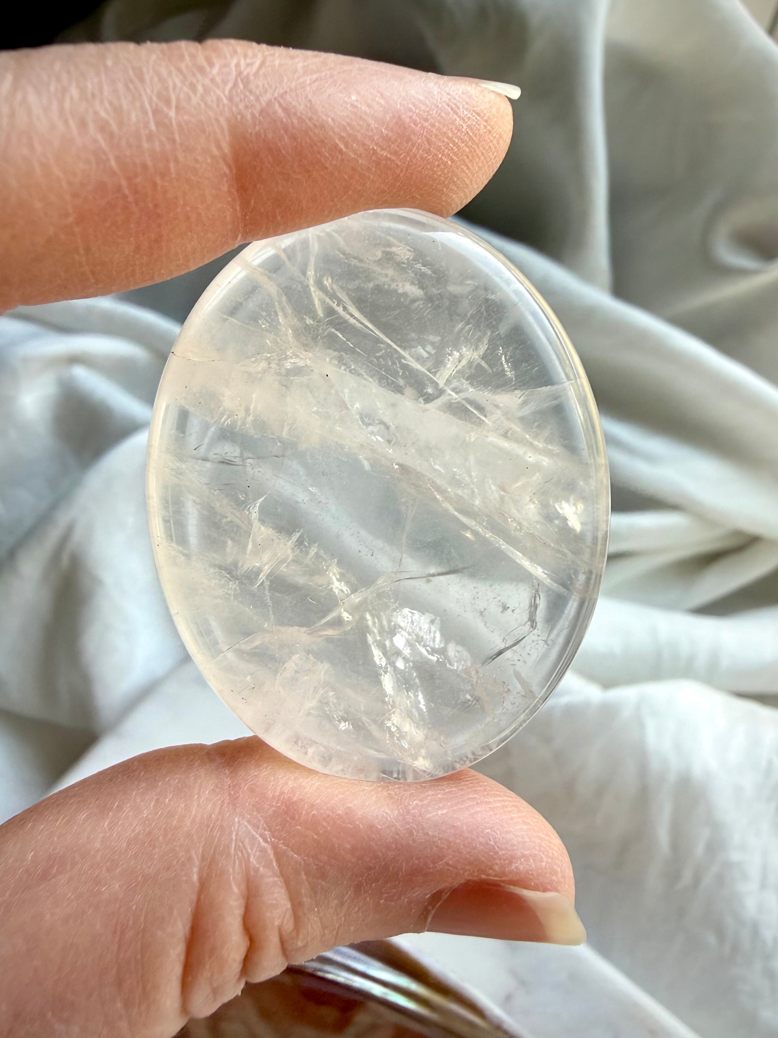 clear quartz palm stone close up showing internal inclusions for clarity and energy amplification