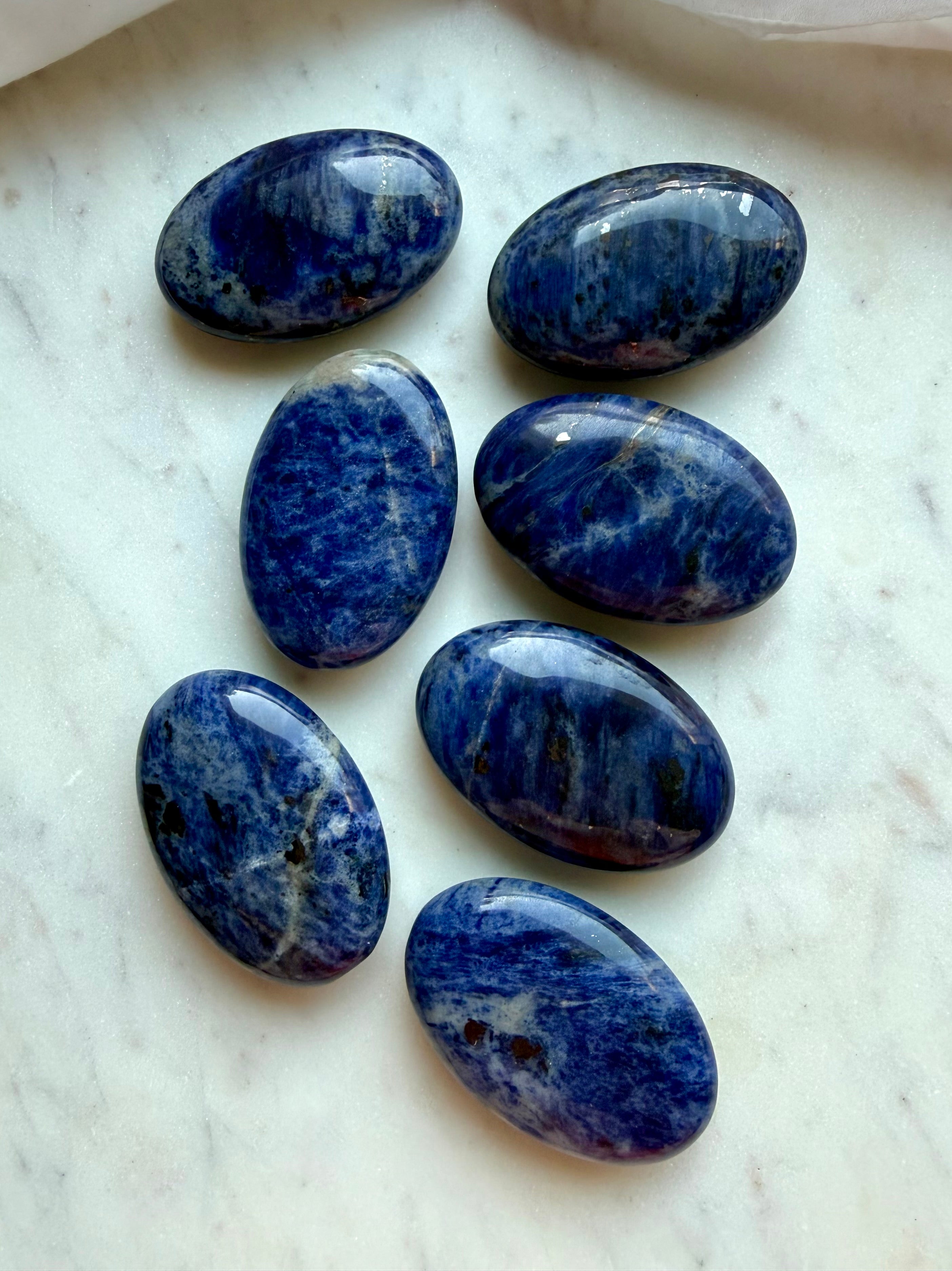 Sodalite palm stones with rich blue color, white veining, and natural mineral patterns