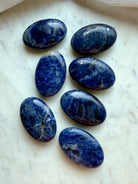 Sodalite palm stones with rich blue color, white veining, and natural mineral patterns
