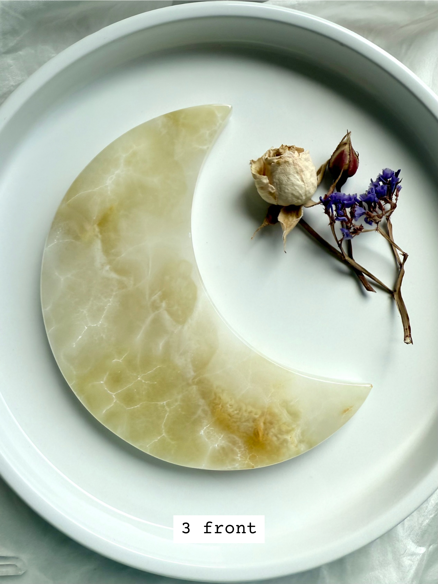 White Onyx Crescent Moon Plate, milky white with natural golden honey swirls, front view.
